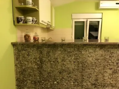 a kitchen with a stone counter top with a mirror at MARE Apartmant in Belgrade