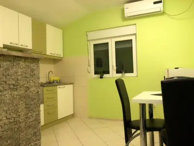 a kitchen with green walls and a table and chairs at MARE Apartmant in Belgrade