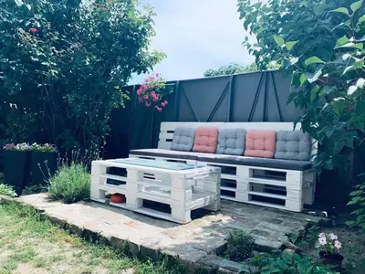a white bench with pillows on it in a garden at MARE Apartmant in Belgrade