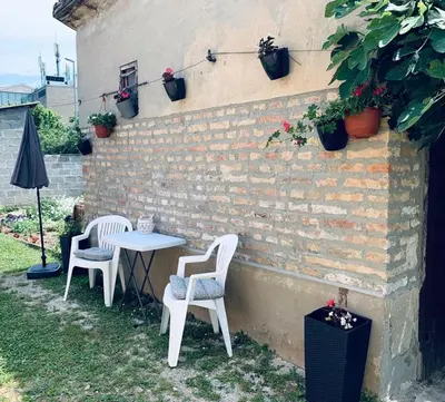 two chairs and a table in front of a brick wall at MARE Apartmant in Belgrade