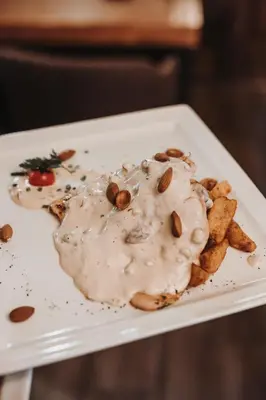 a plate of food with nuts and sauce on it at Avenia Restaurant & Apartments in Ruma