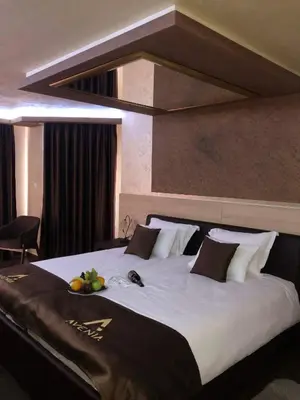 a large bed in a hotel room with fruit on it at Avenia Restaurant & Apartments in Ruma