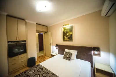 a small bedroom with a bed and a television at Talismano Apartments in Smederevo