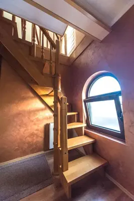 a spiral staircase in a room with a window at Talismano Apartments in Smederevo
