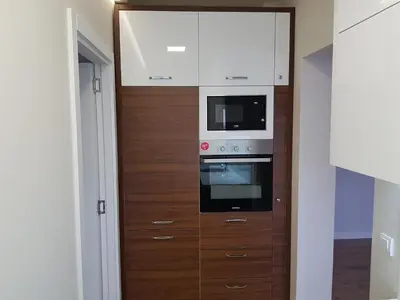 a kitchen with wooden cabinets and a microwave at Krunska 54 in Belgrade