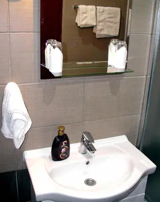 a bathroom with a sink and a mirror and towels at Apartments Skadarlija in Belgrade