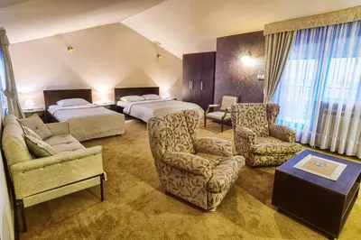 a hotel room with two beds and a chair at Konak Vukasinovic - FREE PARKING in Belgrade