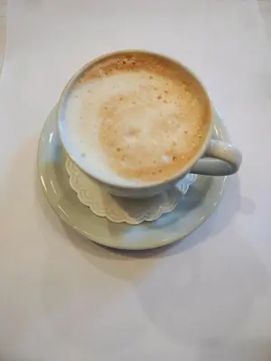 a cup of coffee on a plate on a table at Konak Vukasinovic - FREE PARKING in Belgrade