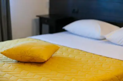 a yellow pillow sitting on top of a bed at Konak Vukasinovic - FREE PARKING in Belgrade