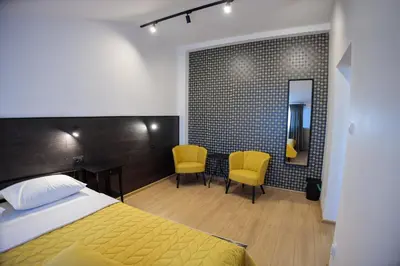 a bedroom with a bed and two chairs and a mirror at Konak Vukasinovic - FREE PARKING in Belgrade