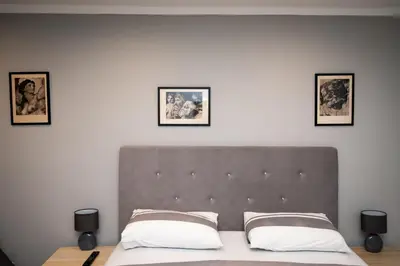 a bedroom with a bed with three pictures on the wall at Marshal apartment in Belgrade