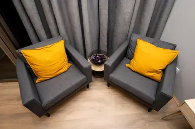 two chairs with yellow pillows in front of a curtain at Marshal apartment in Belgrade
