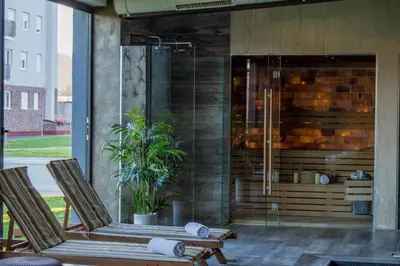 two lounge chairs on a patio with a shower at Hotel Ub Business & Wellness in Ub