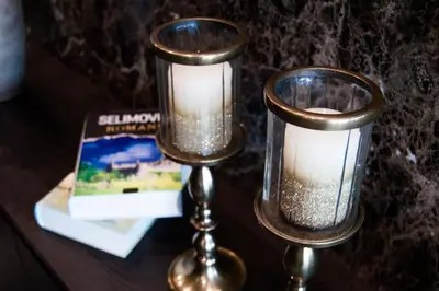 two candles sitting on a table next to a book at Hotel Ub Business & Wellness in Ub