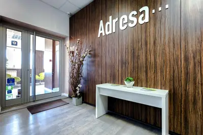 an office with a table and a sign on a wall at Adresa Suites in Belgrade
