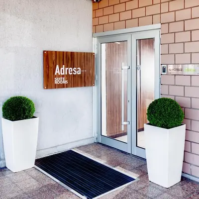 a glass door with two potted plants in front of a building at Adresa Suites in Belgrade