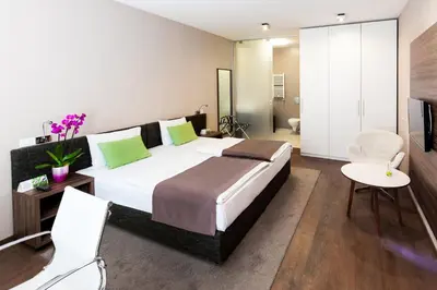 a bedroom with a large bed and a living room at Adresa Suites in Belgrade