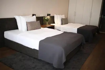 two beds in a hotel room with white and black at Adresa Suites in Belgrade