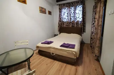 a small bedroom with a bed and a glass table at Apartman Rale in Belgrade