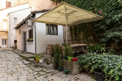 an umbrella sitting outside of a house with plants at Apartman Rale in Belgrade