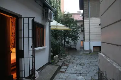 an alley with a building and a cat sitting next to a building at Apartman Rale in Belgrade