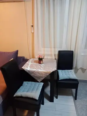 a table with two chairs and a table with flowers on it at MaryAnne in Ledine