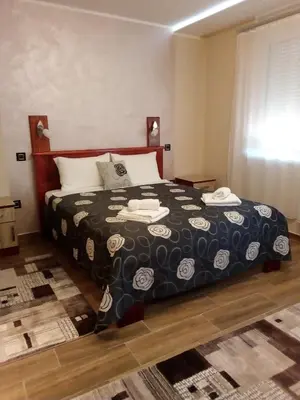 a bedroom with a bed with a black and white blanket at Konak Kutko in Pančevo