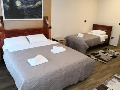 two beds in a hotel room with towels on them at Konak Kutko in Pančevo