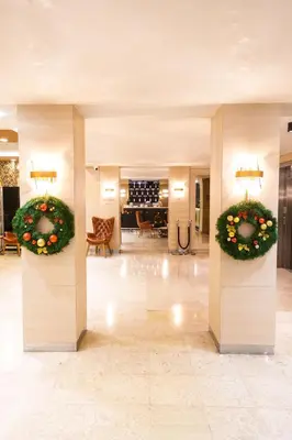 a lobby with two large wreaths on the walls at Hotel Monogram Park in Ruma