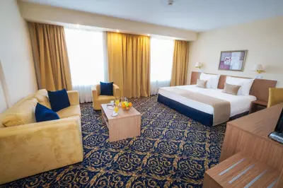 a hotel room with a bed and a couch at Hotel Monogram Park in Ruma