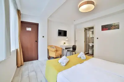 a hotel room with a bed and a desk at Garni House 46 Plus in Belgrade
