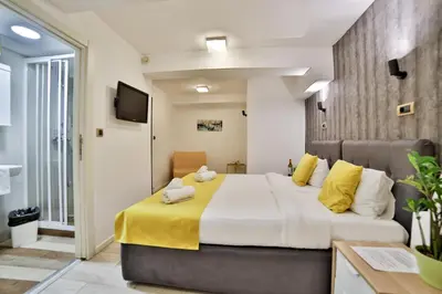 a bedroom with a large bed with yellow sheets at Garni House 46 Plus in Belgrade