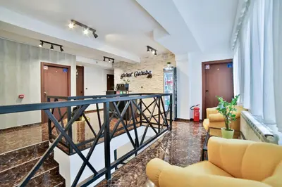 a lobby with yellow chairs and a bar at Garni House 46 Plus in Belgrade