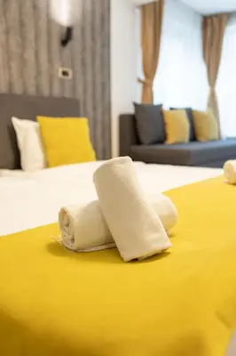 two towels on a bed in a hotel room at Garni House 46 Plus in Belgrade