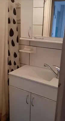 a white bathroom with a sink and a mirror at Downtown Belgrade Hostel and Apartments in Belgrade