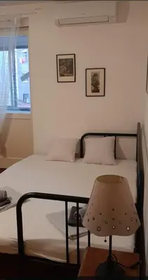 a bedroom with a bed with a chair and a window at Downtown Belgrade Hostel and Apartments in Belgrade