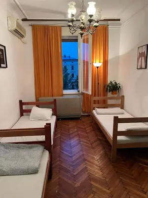 a room with two beds and a window at Downtown Belgrade Hostel and Apartments in Belgrade