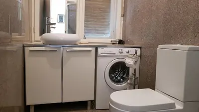 a bathroom with a washing machine and a toilet at Downtown Belgrade Hostel and Apartments in Belgrade
