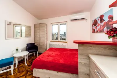 a bedroom with a red bed and a table and chairs at Lux Apartment in Downtown in Belgrade