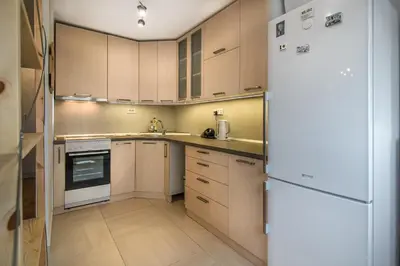 a kitchen with wooden cabinets and a white refrigerator at VortexLuxApatman in Belgrade