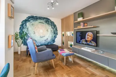 a living room with a blue chair and a tv at VortexLuxApatman in Belgrade