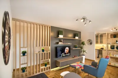 a living room with a tv and a blue chair at VortexLuxApatman in Belgrade