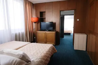 a hotel room with two beds and a flat screen tv at Hotel Slavija in Belgrade