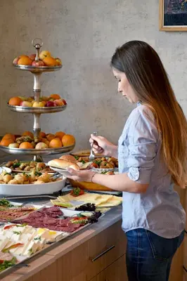 a woman standing in front of a buffet of food at Hotel Slavija in Belgrade