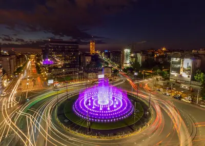 a large fountain in the middle of a city at night at Hotel Slavija in Belgrade