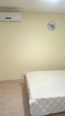 a bed in a room with a clock on the wall at Djurdja 2 Apartman in Arandjelovac