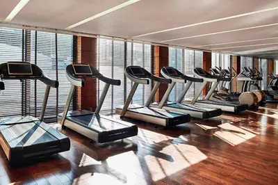 a row of treadmills in a gym with windows at Metropol Palace, Belgrade in Belgrade