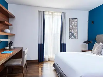 a bedroom with a large white bed and a desk at Metropol Palace, Belgrade in Belgrade