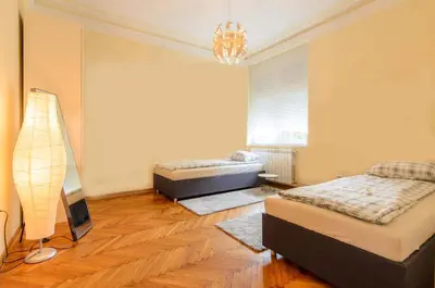 a bedroom with two beds and a lamp in it at Gundulic in Belgrade
