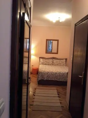 a bedroom with a bed and a mirror and a door at Studio Hram 2 in Belgrade